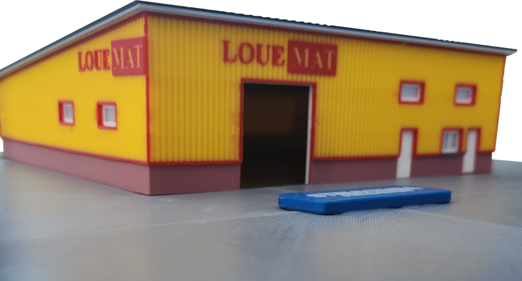 Maquette industrielle 1:100, gros plan sur le bardage nervuré et l'enseigne en relief